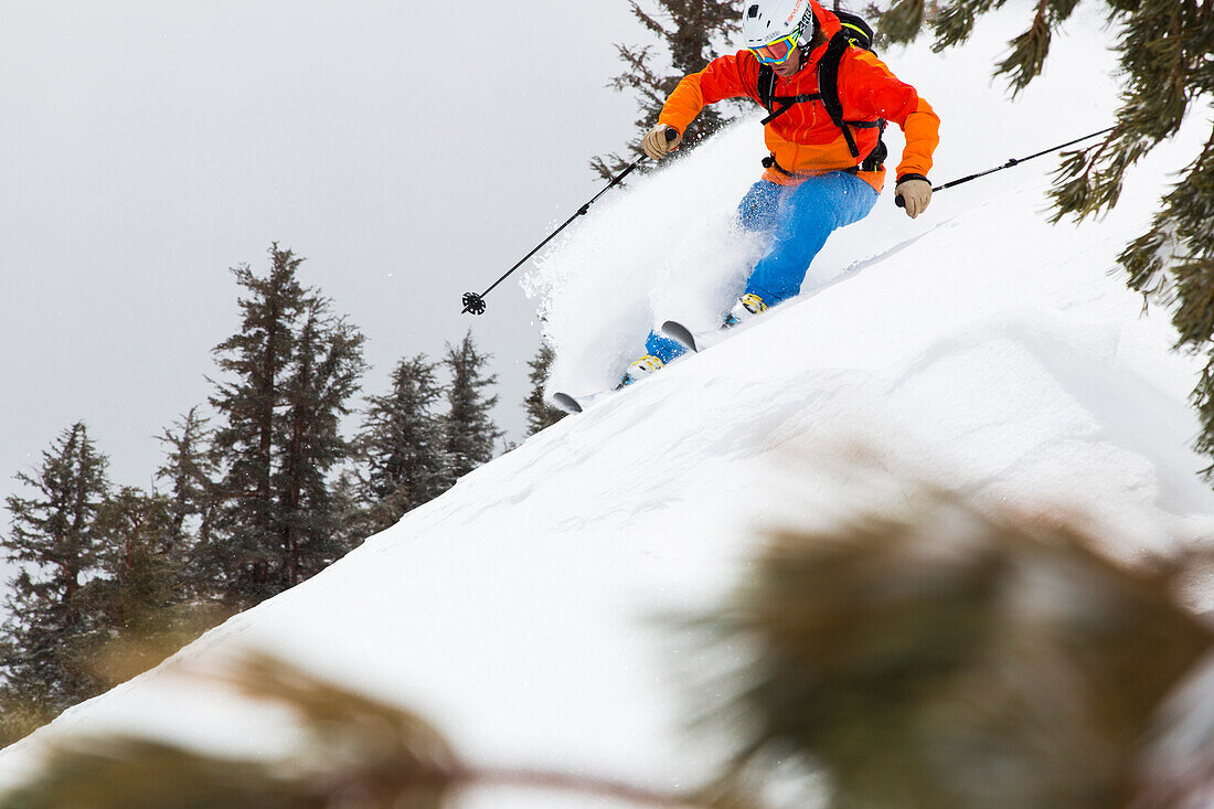 Man downhill skiing in deep snow, Mammoth Mountains, California, USA