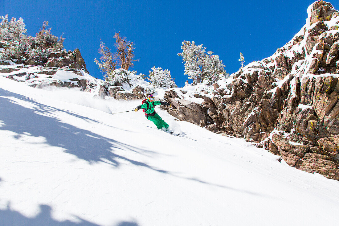 Man downhill skiing in deep snow, Mammoth Mountains, California, USA