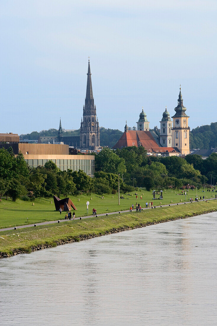 The flood zone of the Danube is normally a green park. Steeples of the new cathedral, Mary-Immaculate-Conception and parish church in the background, Linz, Upper Austria, Austria
