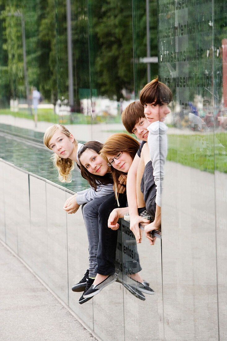 Reflection of young people in the facade of Lentos Art Museum for modern and contemporary art, Linz, Upper Austria, Austria