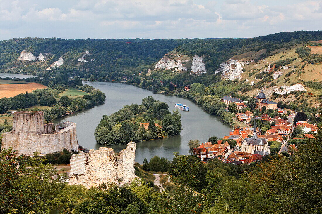Ruins of chateau Gaillard above the Seine with a cruise ship and Ile du Chateau and the village Le Petit Andely, Normandy, France