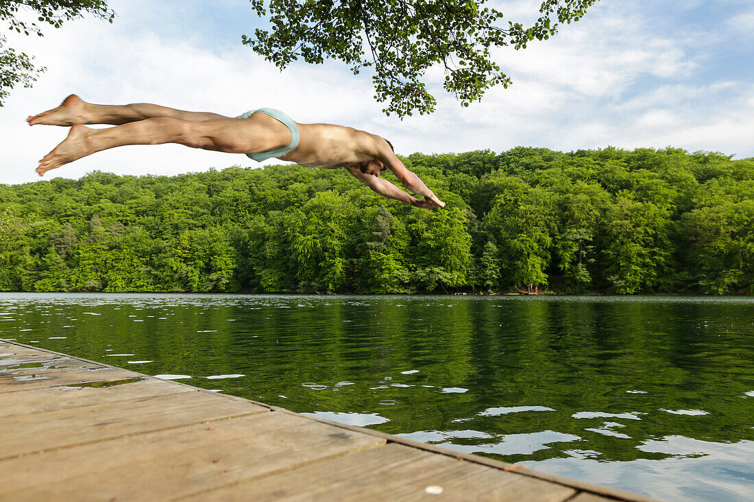 Man jumping into lake Schmaler Luzin, Feldberger Seenlandschaft, Mecklenburg-Western Pomerania, Germany