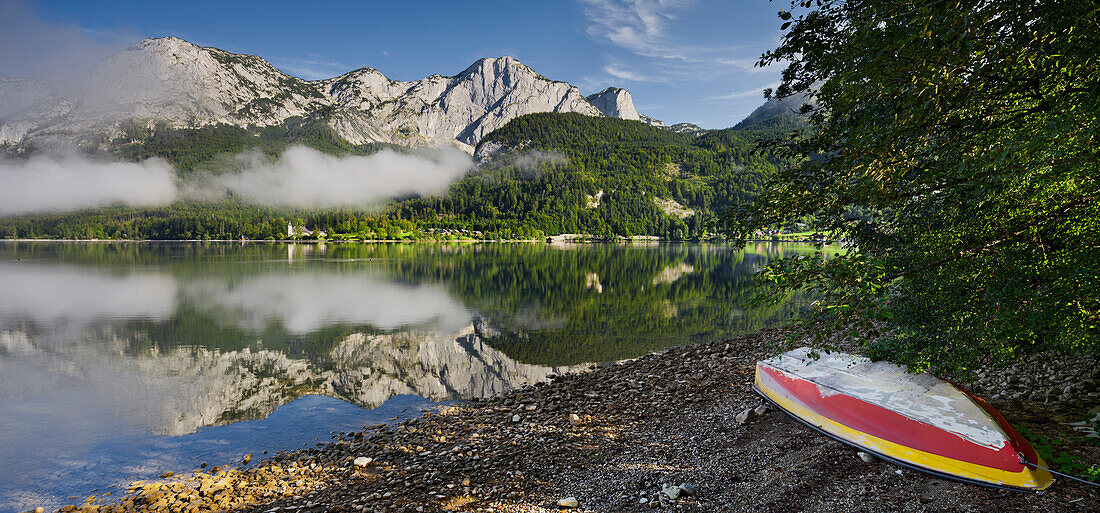 Boat at lake Grundlsee with Backenstein and Reichenstein reflected in the water, Salzkammergut, Styria, Austria