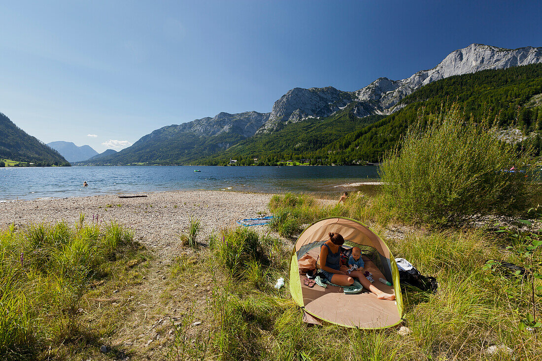 Mother and baby in a sun shelter at lake Grundlsee, Goeßl, Salzkammergut, Styria, Austria