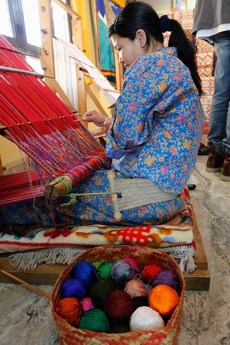 Bhutan (kingdom of), District of Paro, the City of Paro, in Chencho Handycraft shop, Mrs Chuki Wangmo and her very nice daughter Tandin Bidha, a movie actress, weaver at loom weaving traditional fabric // Bhoutan (Royaume du), district de Paro, la ville d