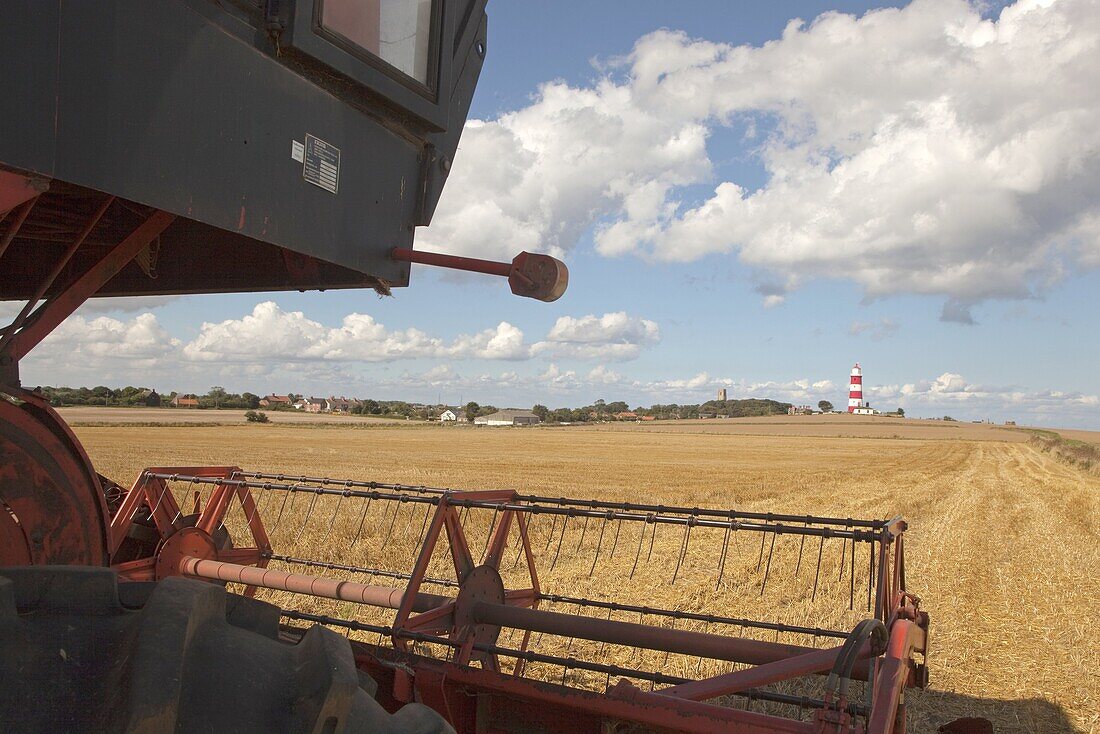 Combine harvester,Light House & Church Happisburgh Norfolk UK September