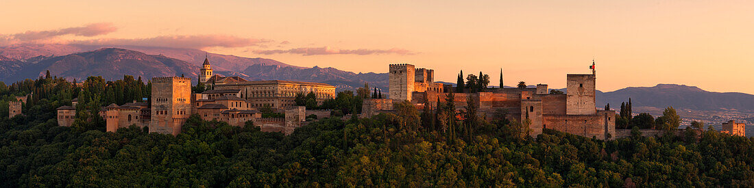 Panorama der Alhambra im Abendlicht mit Bergen der Sierra Nevada im Hintergrund, Granada, Andalusien, Spanien