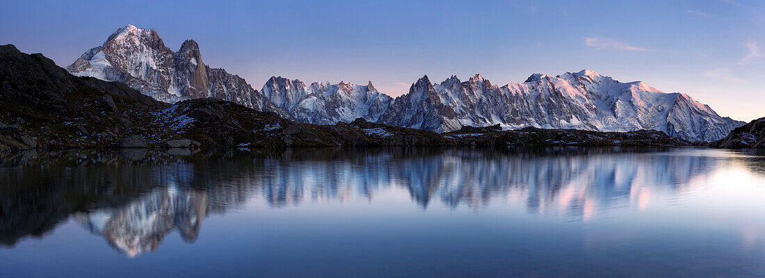 Panorama des Mont Blanc Massivs in der Abenddämmerung mit Spiegelung im Bergsee Lac de Chésery im Herbst, Chamonix Tal, Haute-Savoie, Frankreich