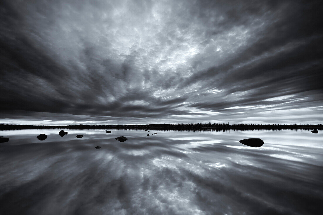 Black and white shot of the lake Muddusluobbal with reflection, Muddus National Park, Lapland, Sweden