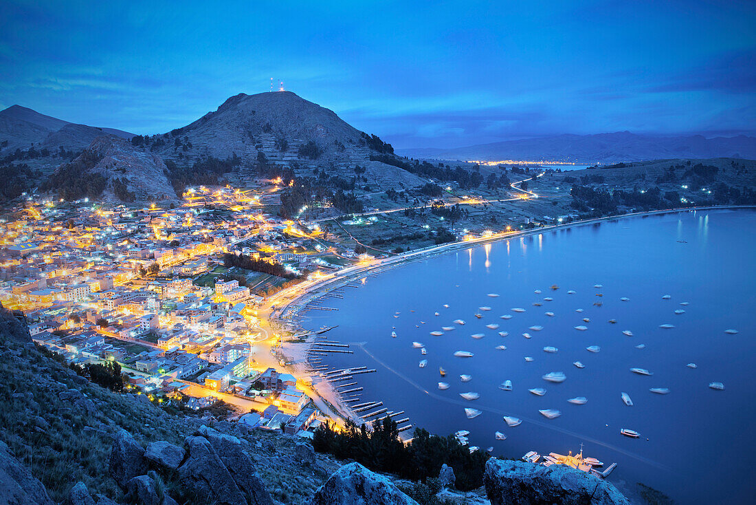 View of Copacabana from Cerro Calvario mountain at night with boats, houses and harbour, lake Titicaca, Bolivia, Andes, South America