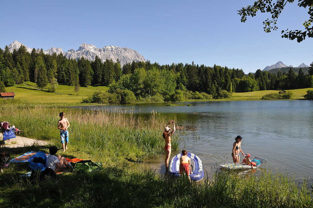 People bathing in Lake Tennsee, Karwendel mountain range near Mittenwald, Bavaria, Germany