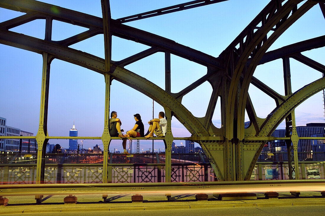 People sitting on the Hacker bridge in the evening, Munich, Bavaria, Germany