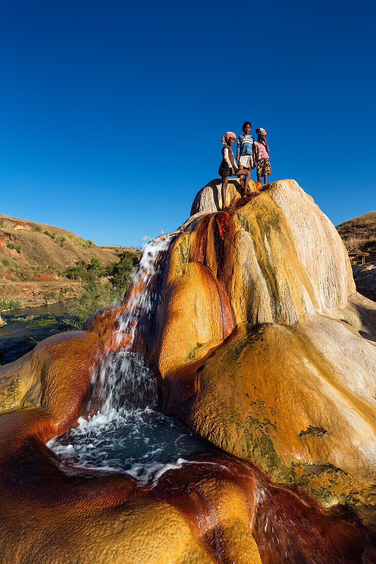 Madagassische Kinder beim Spielen, spuckender Geysir, Geysire von Ampefy, Hochland, Madagaskar, Afrika