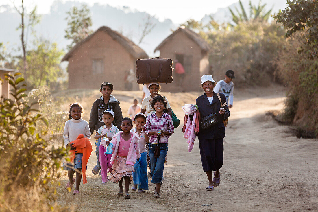 Madagassen gehen auf staubiger Straße bei Ampefy, Stamm der Merina, Madagaskar, Afrika