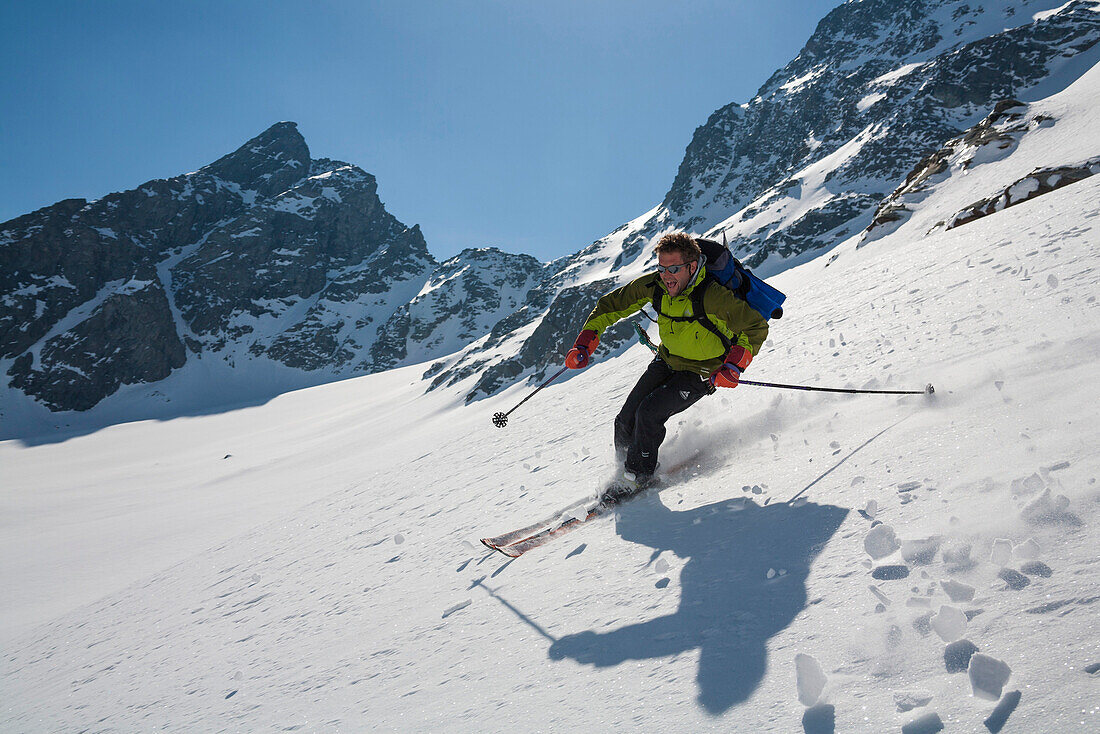 Man downhill skiing from mount Wasuhorn, Turtmannvalley, Canton of Valais, Switzerland