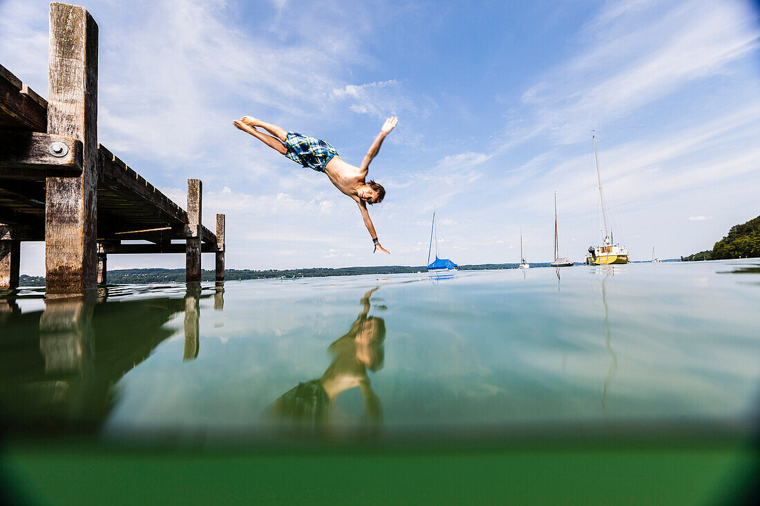 Junge springt in Starnberger See, Bayern, Deutschland