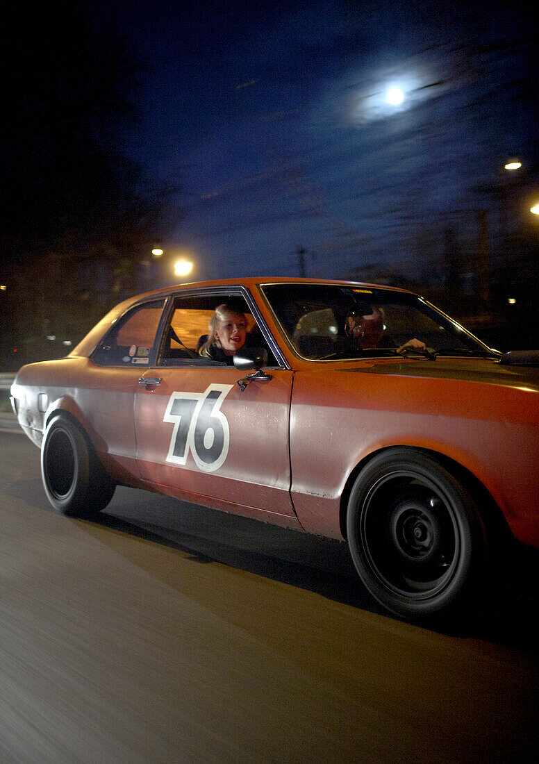 Couple in modern classic car at night, Motoraver group, Hamburg, Germany