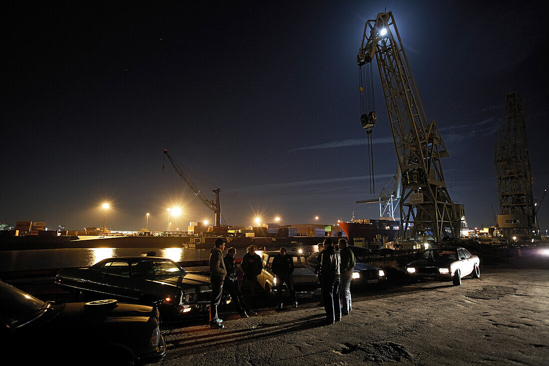 Motoraver group with modern classic cars meeting in harbor at night, Hamburg, Germany