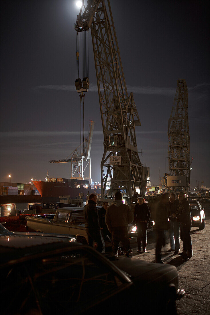 Motoraver group with modern classic cars meeting in harbor at night, Hamburg, Germany