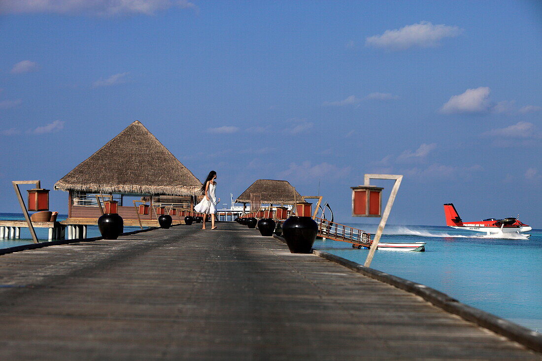 Republic of the Maldives, Lhaviyani Atoll,  Kanuhura Hotel, woman walking on the landing stage
