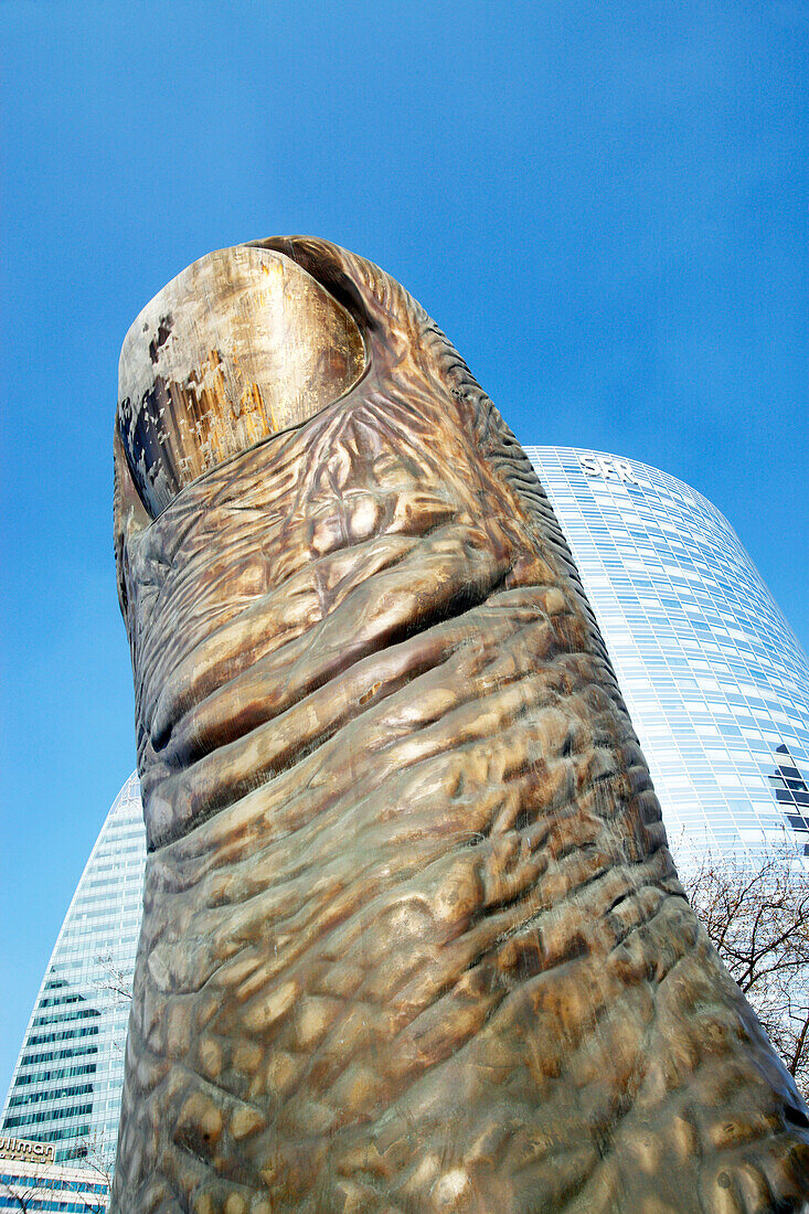 'France, Paris, La Défense, close up of the sculpture ''Thumb'' of Ceesar, SFR tower in the background'