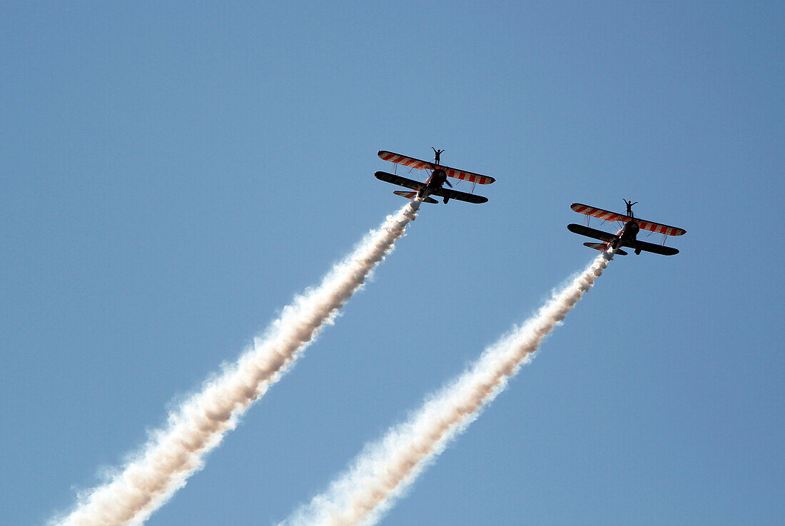 France, Essonne, La Ferte Alais, Airshow 2012. Wing Walkers on Stearman aircraft in full aerobatics.