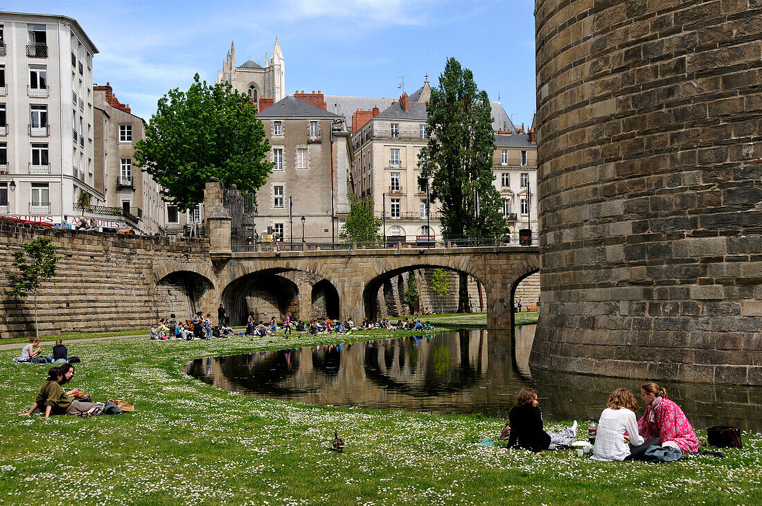 'France, Pays de la Loire, Nantes, Château des Ducs de Bretagne - ''Castle of the Dukes of Brittany'', rue Prémion, People resting on the lawn of the moats'