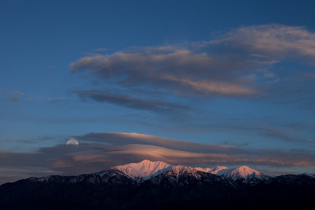 Lenticular cloud formation over Mt Canigou, rising full moon,  Eastern Pyrenees, France