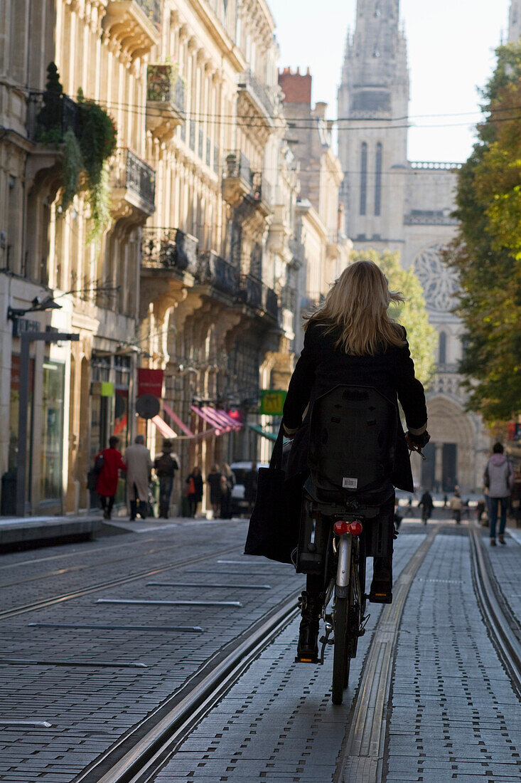 France, Bordeaux, Southwestern France, Aquitaine, rue Vital Carles, Woman cycling on a tram track