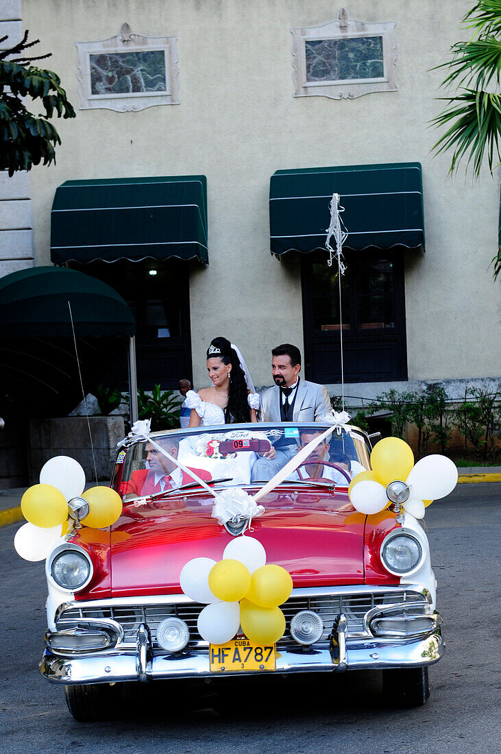 Bride and groom in a vintage car in Havana, Cuba