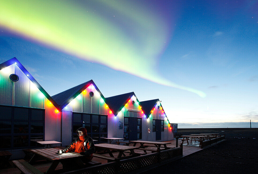 Iceland. Southeastern Region. Jokulsarlon. Man under an aurora borealis.