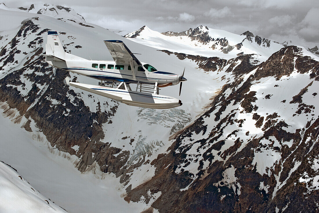 Cessna Caravan Amphibian Seaplane Flying Through The Coast Mountains, British Columbia Canada