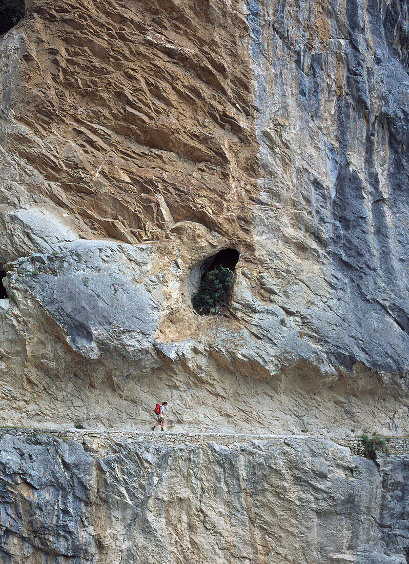 Walker In A Cutting In Face Of Cliff