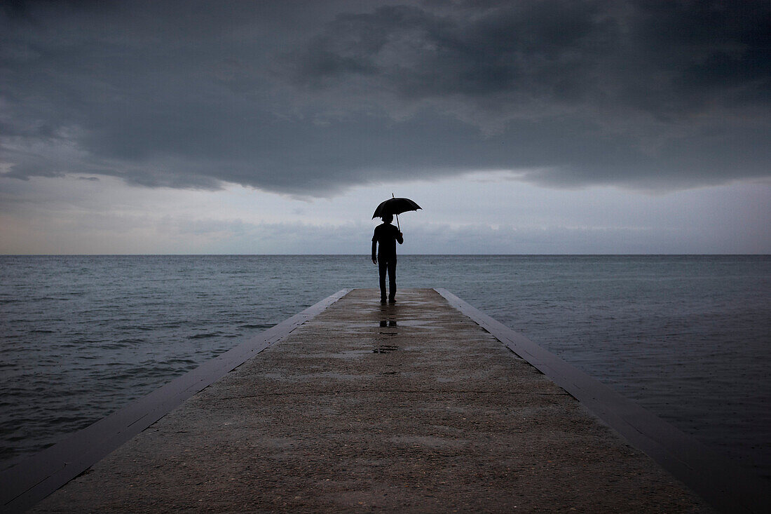 Man with Umbrella Standing on Pier, Woodbine Beach, Toronto, Ontario