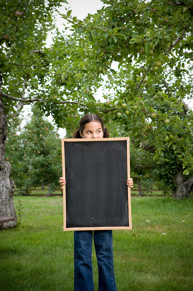 Girl on Apple Farm holding Blank Chalkboard