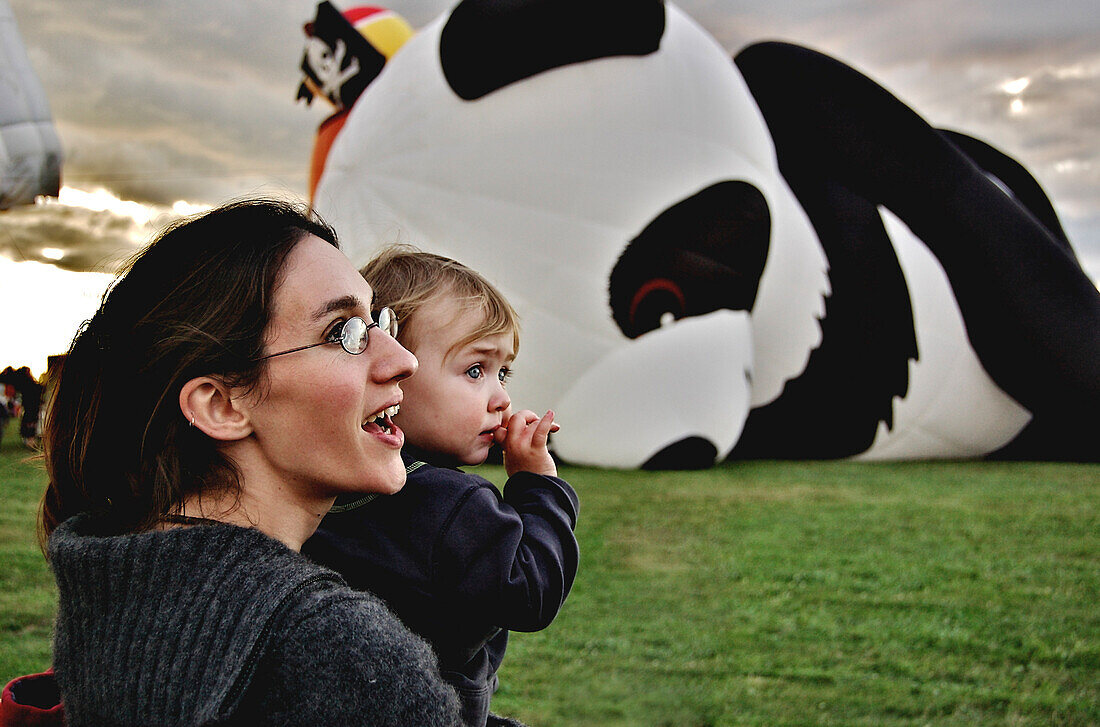 Mother and child watching giant hot-air balloons at the fair, St-Jean sur Richelieu, Quebec