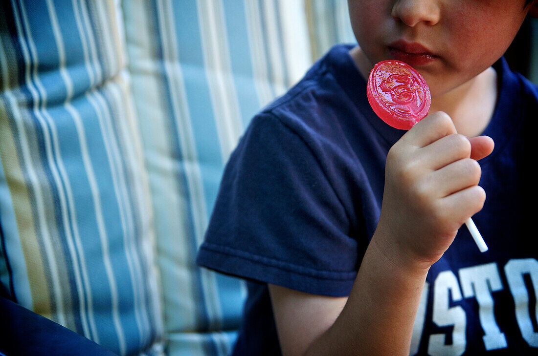 Boy eating a red lollipop, Otterburn, Quebec