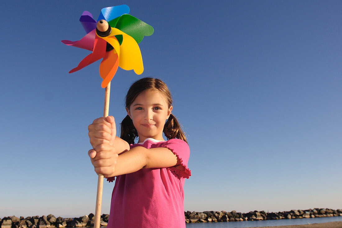 Girl Standing on Beach Holding Pinwheel, Toronto, Ontario