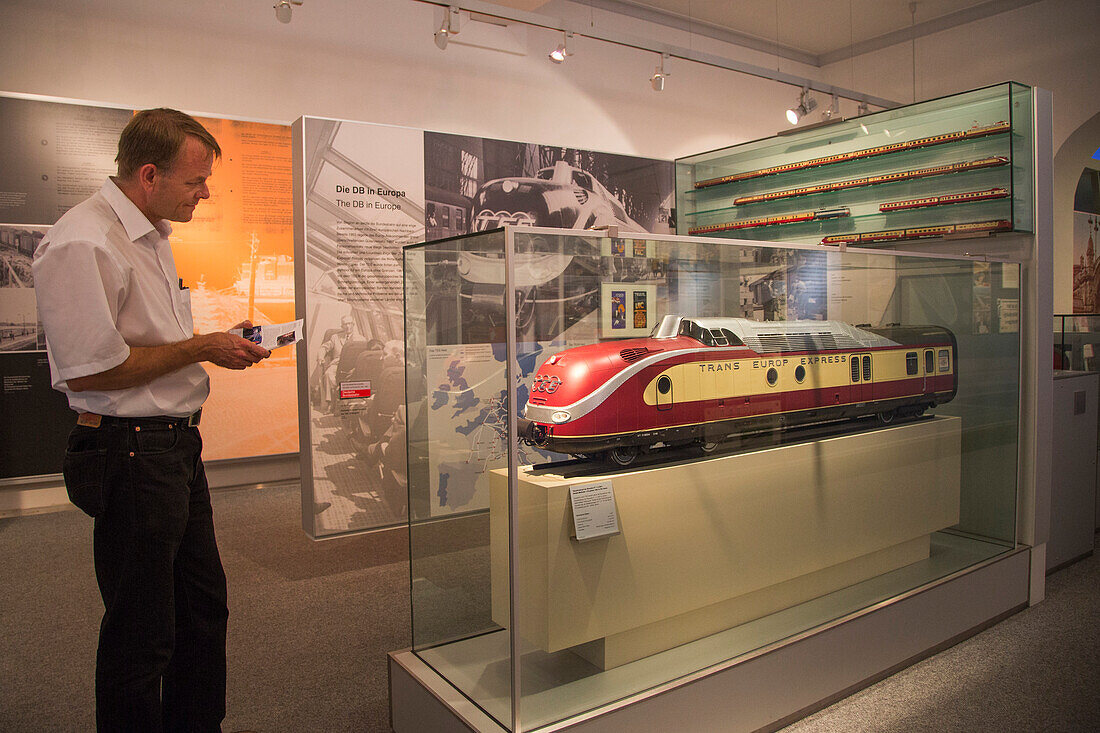 Man admiring a model of the TEE Trans Europe Express train in the German Railways train museum, DB Museum, Nuremberg, Franconia, Bavaria, Germany