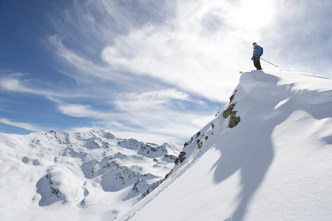 Skifahrer steht an einem Tiefschneehang, Davos, Graubünden, Schweiz