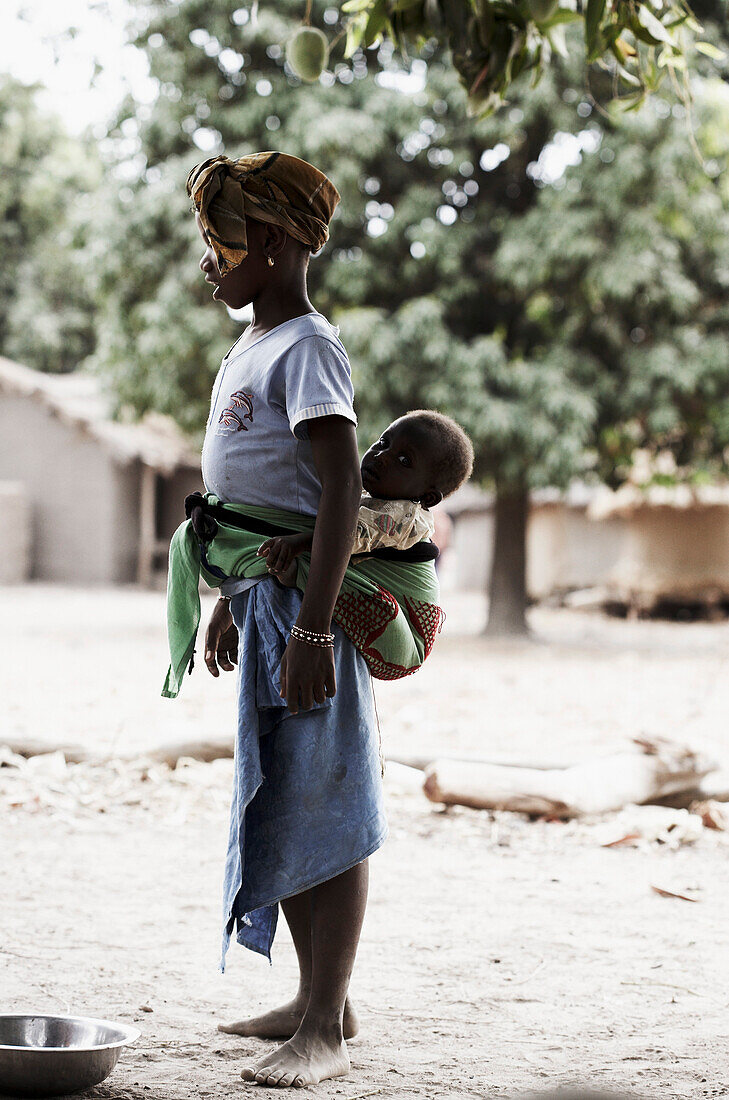 Mädchen trägt ein Baby auf dem Rücken, Magadala, Mali