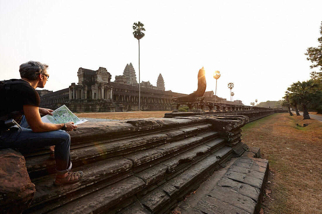 Visitor sitting on stairs, Angkor Wat temple, Angkor Archaeological Park, Siem Reap, Cambodia