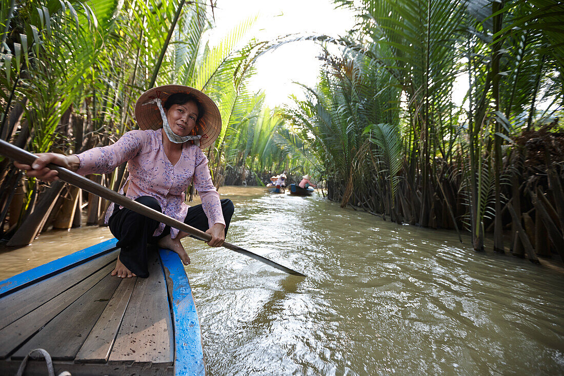 Frau paddelt Touristenboot durch Kanal, Einhorninsel Thoi Son, My Tho, Tien Giang Provinz, Vietnam