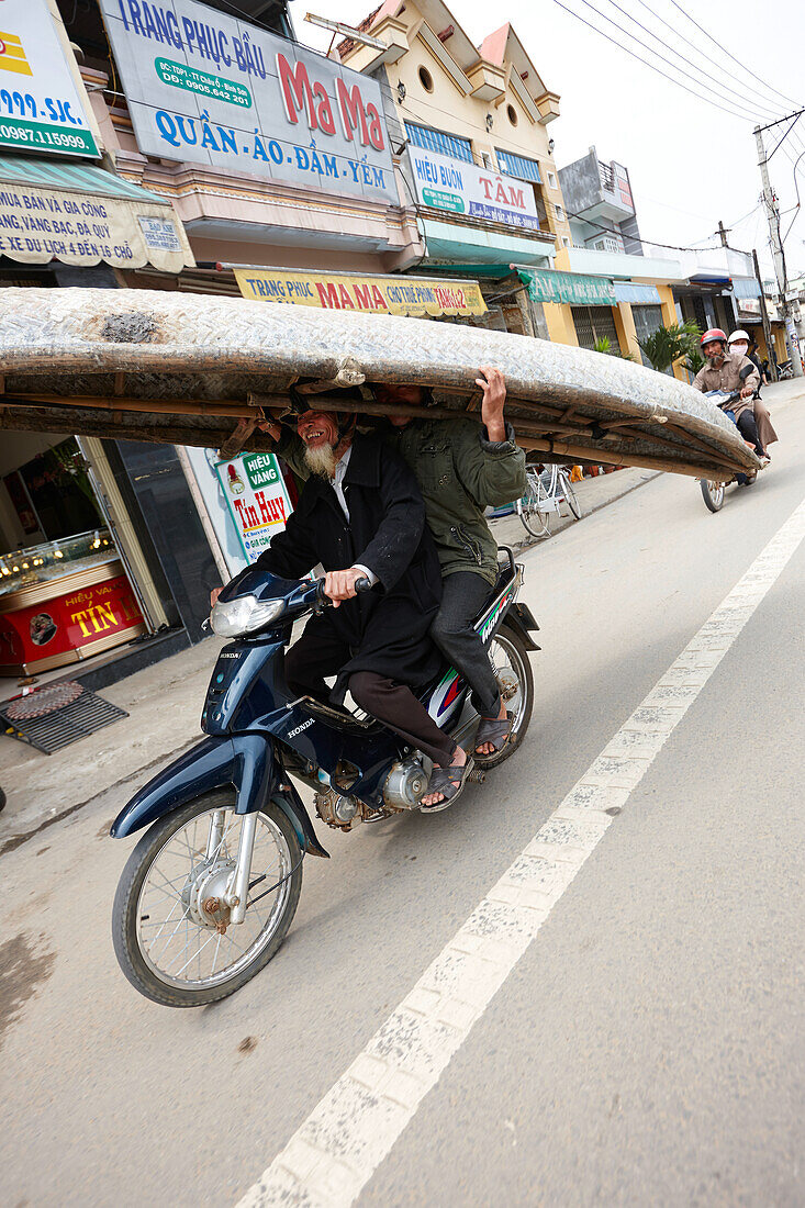 Men carrying old plaited boat on a motorbike, Quang Ngai, Vietnam