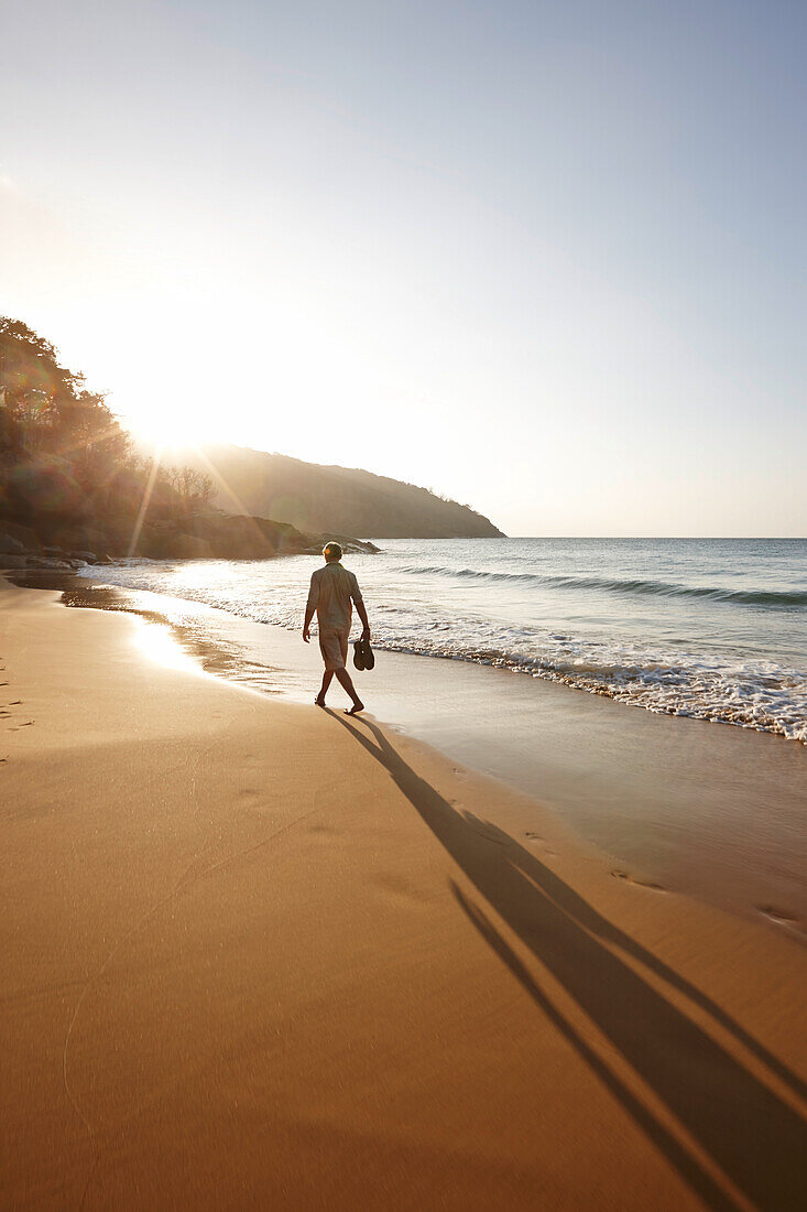 Man walking along Dam Trau beach in the evening, Con Dao Island, Con Dao National Park, Ba Ria-Vung Tau Province, Vietnam