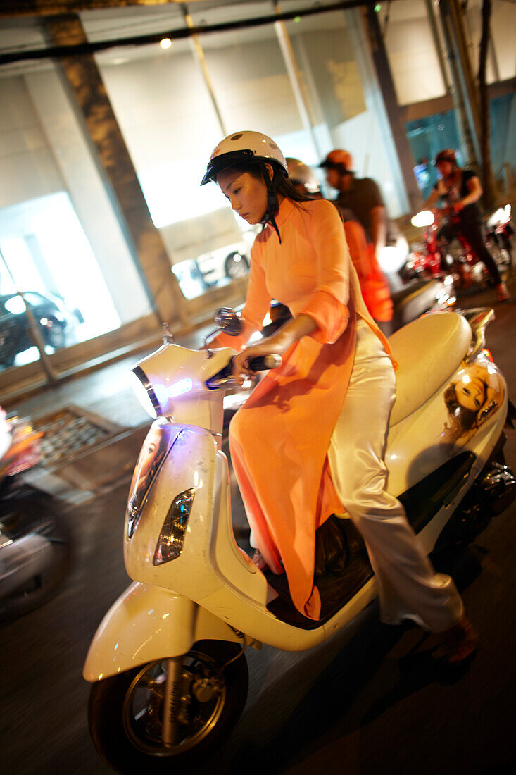 Frau fährt auf einer Motorroller im Zentrum, Ho-Chi-Minh-Stadt, Vietnam