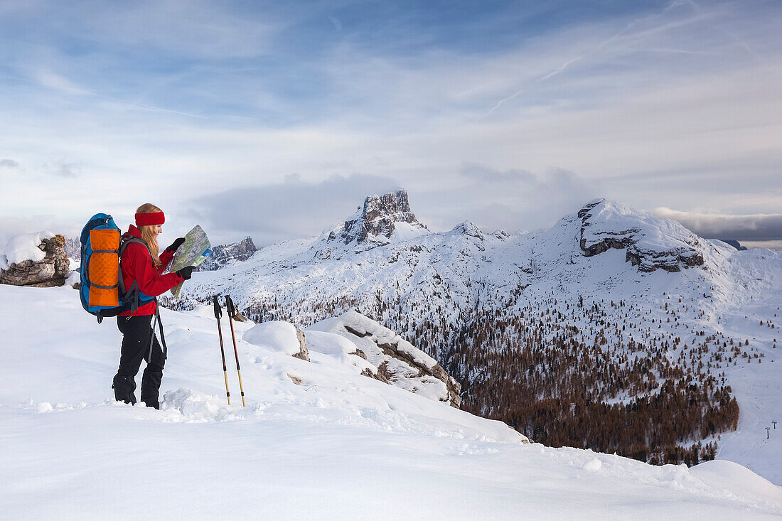 Young woman reading a hiking map, Fanes-Sennes-Prags Nature Park, valley of the Passo di Falzarego, the Dolomites, Belluno, Veneto, Italy