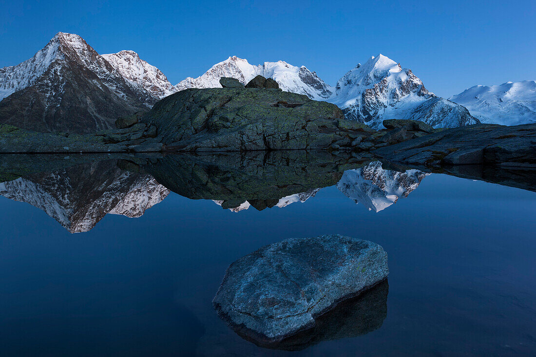 Berninagruppe spiegelt sich in einem Bergsee, Engadin, Kanton Graubünden, Schweiz