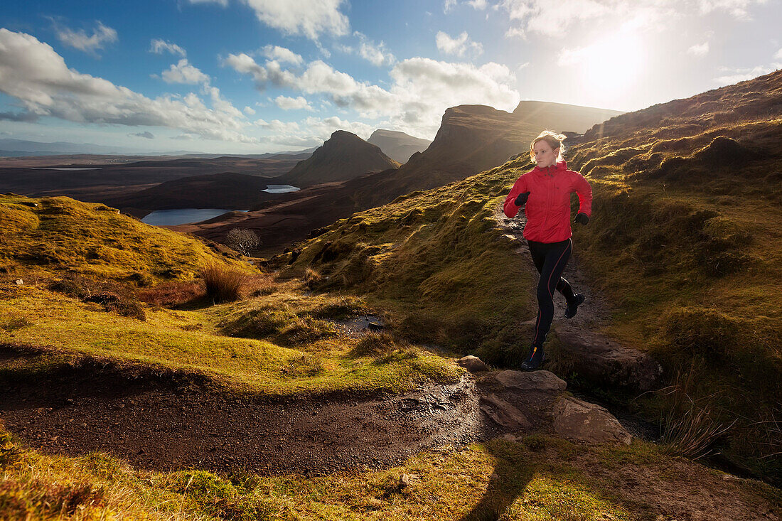 Junge Frau läuft über einen Wanderweg, Quiraing, Trotternish Halbinsel, Isle of Skye, Schottland, Großbritannien