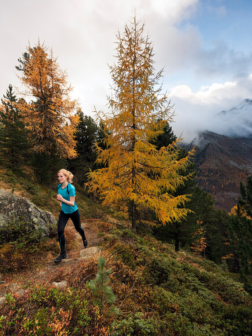 Young woman running on a trail, Stelvio National Park, South Tyrol, Italy